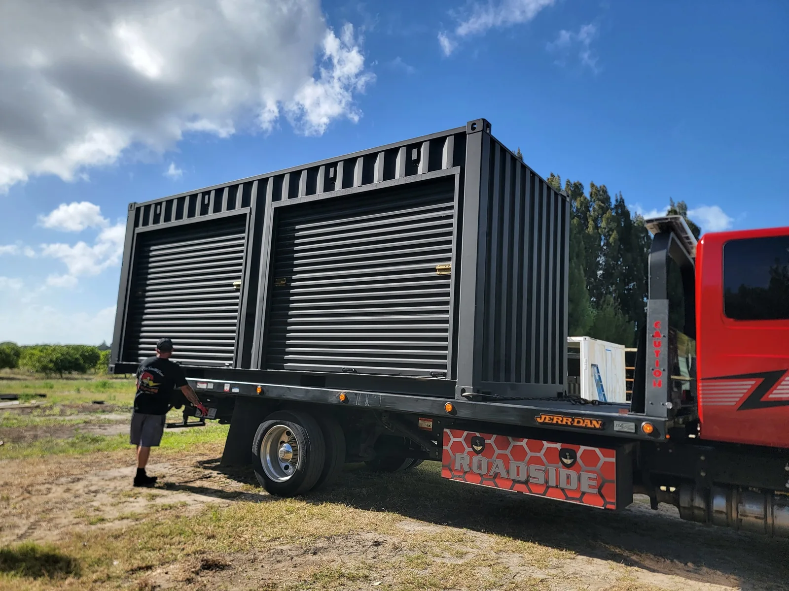 Black shipping container with two roll-up doors on a delivery truck.