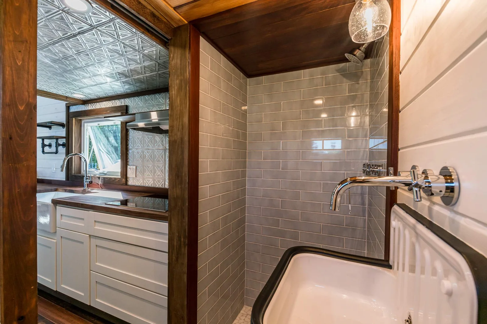 Finished tiny house bathroom with tiled shower and vanity.